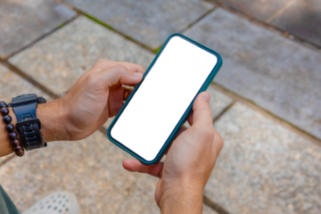 Man holding phone blank screen in the garden, outdoor. Phone mockup	