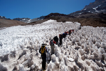 The movement of climbers in rows in extreme conditions on snowy, steep mountains