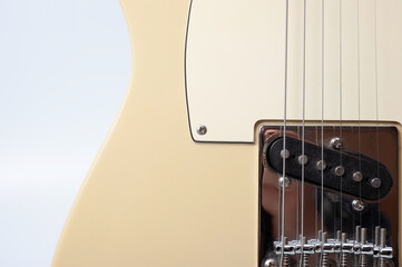 Six-string electric guitar, with a cream-colored wooden body and chrome-plated fittings.