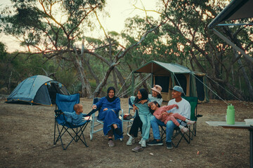 A joyful family gathering around a campfire, enjoying nature and togetherness during their camping trip.