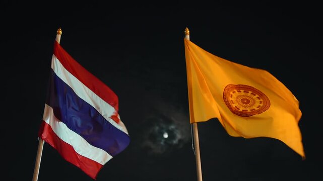 Thailand national flag and buddhist flag waving at night
