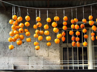 Kinglet fruit, dried fruit on ropes on the balcony. Orange circles, healthy eating. High quality
