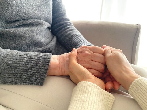 Close up of caring hands supporting senior person