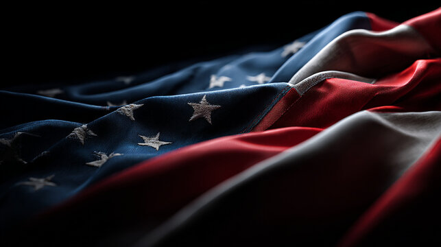 A close-up view of the American flag with a dramatic lighting effect on a dark background