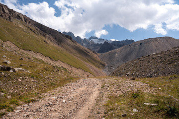 High-altitude mountain pass in the Trans-Ili Alatau range. Gravel road among Tuyuk-Su glaciers and rocky valleys, Tien Shan, Central Asia