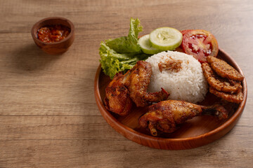 Indonesian Ayam Goreng Fried Chicken with Rice, Sambal, and Fresh Salad. Perfect for recipes, articles or any cooking content.