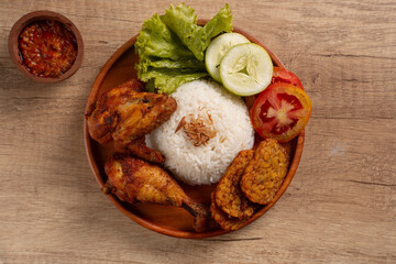 Indonesian Ayam Goreng Fried Chicken with Rice, Sambal, and Fresh Salad. Perfect for recipes, articles or any cooking content.