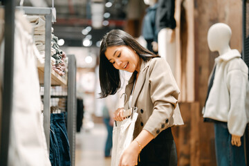 Obraz premium Happy asian business woman shopping clothing shop in department store after work life baclance modern lifestyles retail therapy single person