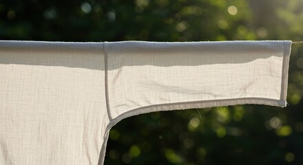 Lightweight clothing textile hanging outdoors in vivid daylight, emphasizing breathability, comfort, and natural fiber ,surface ,outdoor ,lightweight