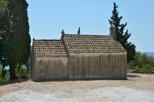 The traditional stone architecture of the chapel of Saint Roch located in Karmen near Orebic features a weathered facade and tiled roof under a bright blue sky