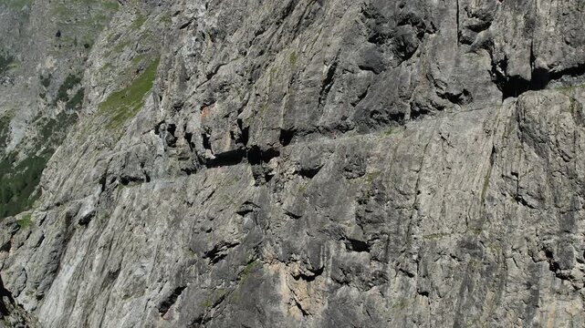 Cinematic Drone Shot of Couple Hiking Rocky Alpine Cliff in Swiss Alps &ndash; Adventure, Freedom and Epic Mountain Landscape