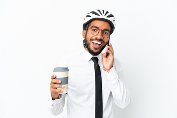 Young business latin man holding a bike helmet isolated on white background holding coffee to take away and a mobile