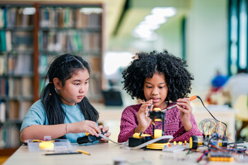 Two girl practices technology learning, knowledge sharing experience, supports collaborative robotics experiment, innovation driven education.