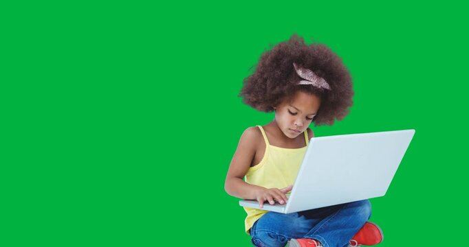 African american girl using laptop while sitting against black background
