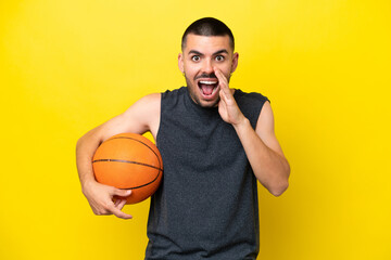 Young caucasian basketball player man isolated on yellow background with surprise and shocked...