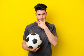 Handsome young football player man isolated on yellow background thinking