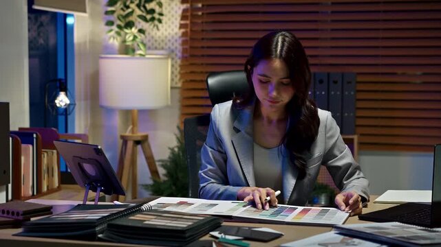 Women interior designer working in office at night.