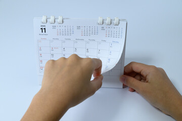 Hands of a person flipping a page of a desk calendar