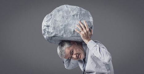 A Businessman Struggling to Hold a Heavy Boulder Above His Head