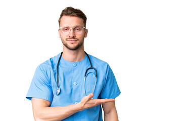 Young nurse man over isolated chroma key background presenting an idea while looking smiling towards
