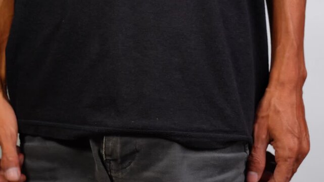 Person discreetly concealing or retrieving small plastic bottle filled with white pharmaceutical pills into front jeans pocket