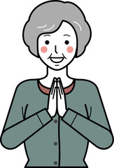 正面向き。いただきますと手を合わせるカーディガンを着た高齢女性。