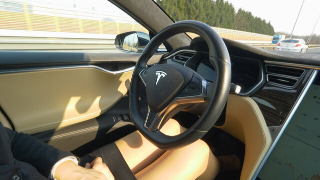 CLOSE UP: Unknown businesswoman driving to work in her self steering Tesla car.