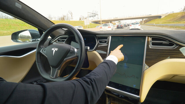 CLOSE UP: Unrecognizable stylish woman setting up navigation in autonomous car.
