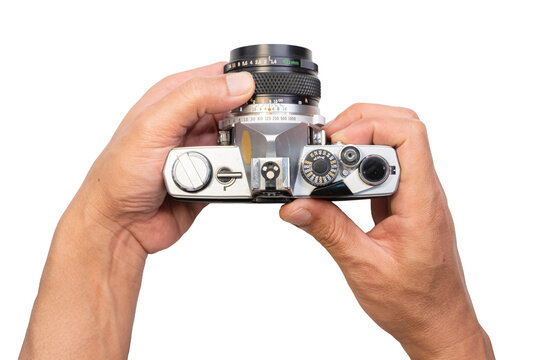 A professional photographer holding Vintage-Old Film Camera in hand to take a picture with the lens and blank display screen isolated on a white frame