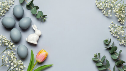 Easter-themed flat lay with eggs, flowers, and a rabbit figurine on pastel background.