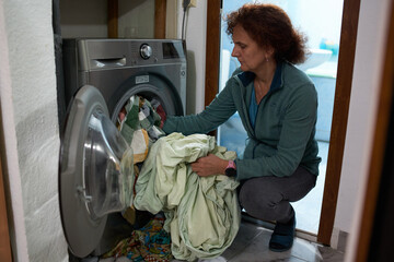 Woman loading the washing machine © Xalanx