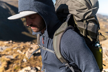 Introspective backpacker descending rugged trail in high mountain light