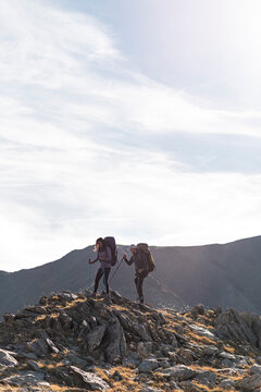 Weekend wanderers traversing rocky ridge in quiet mountain isolation
