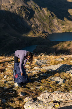 Grounded female hiker unpacking gear during quiet mountain pause