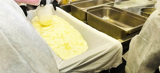 Workers preparing dairy product in a kitchen setting during day time in a commercial kitchen