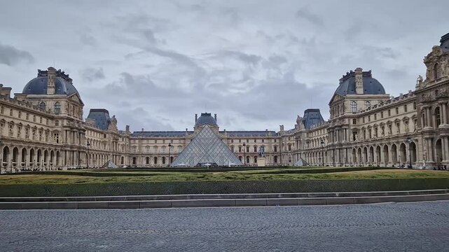 Paris, France - December 10, 2025: Woman tourist visiting the Louvre Museum in Paris, admiring the intricate, historic French Renaissance architecture of the palace as walking the courtyard