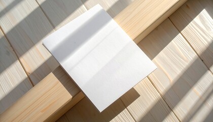 A pristine blank white sheet of paper bathed in natural sunlight, resting on light wooden planks, casting dynamic shadows, perfect for a minimalistic design or text mockup