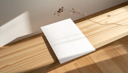 Blank white paper sheet placed on a wooden surface with soft light and shadow, creating a minimalist and clean aesthetic