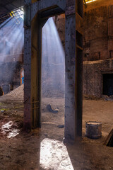 Abandoned industrial hall with steel frame and light rays