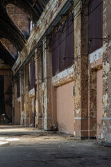 Abandoned industrial hall interior with peeling walls