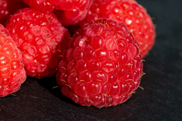 Fresh appetizing ripe raspberries in a detailed macro shot showing texture and vibrant red color