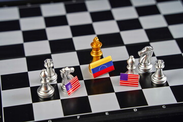 The golden king chess piece with the flag of Venezuela and the pieces with the flags of the USA.