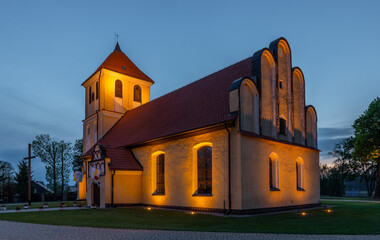 Illuminated historic church at dusk in Rydzewo Masuria. Poland.