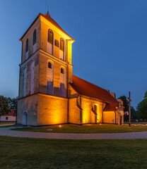 Illuminated historic church at dusk in Rydzewo Masuria. Poland.