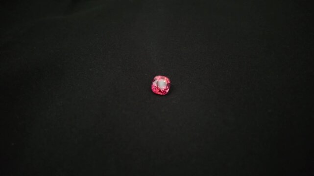 Camera video of red ruby gemstone on black background