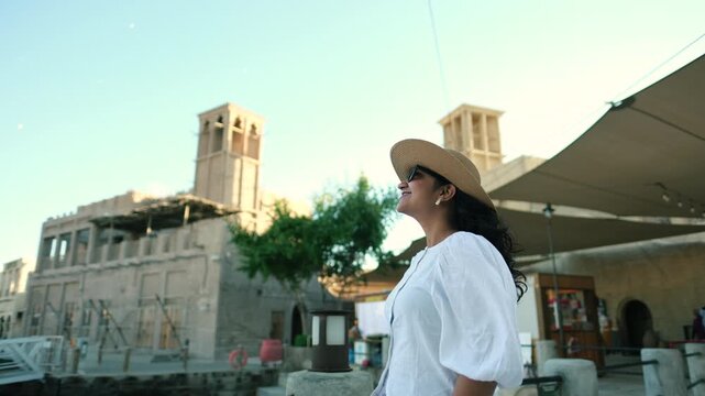 video of woman exploring Old Dubai heritage area with traditional Emirati architecture, Al seef, Al Fahidi , Bastakiya 