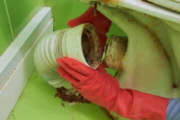 The process of replacing a corrugated toilet pipe, Disconnecting a corrugated toilet pipe, Removing a flexible toilet sewer connection