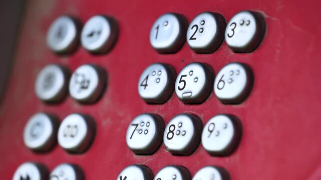 Vintage red payphone with keypad and handset representing old communication technology