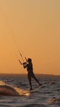 cinematic kitesurfer silhouette magical orange sunset slow motion jumps and turns adrenaline beauty extreme