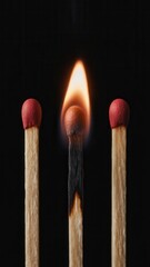Closeup of a burning matchstick centered between two unlit matchsticks against a dark background, symbolizing leadership or uniqueness